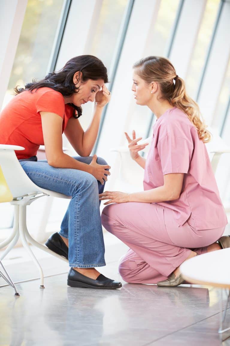 Female Nurse Offering Counselling To Depressed Woman